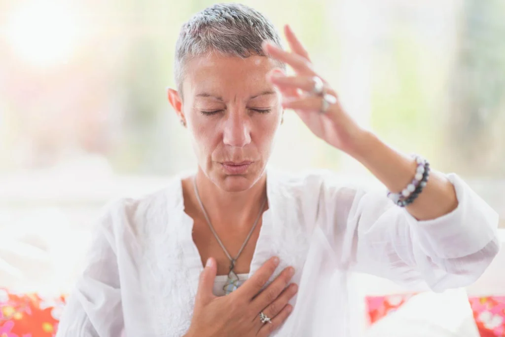 Mindful woman meditating, developing intuition with hand gestures